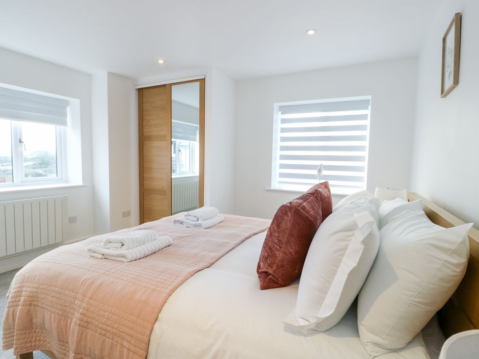 A bedroom with a bed and pillows at Glynllifon 6 in Marianglas