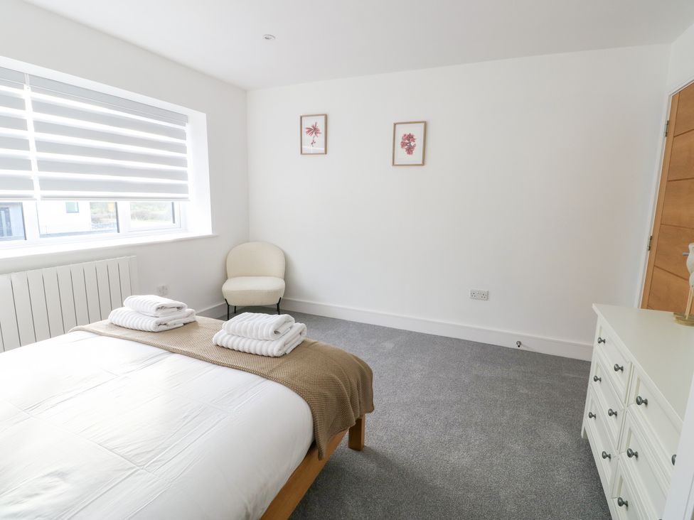 A bedroom with a bed and towels at Glynllifon 6 in Marianglas