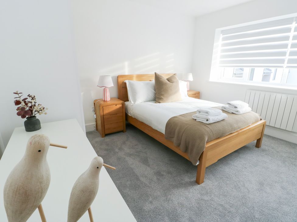 A bedroom with a bed and nightstand at Glynllifon 6 in Marianglas