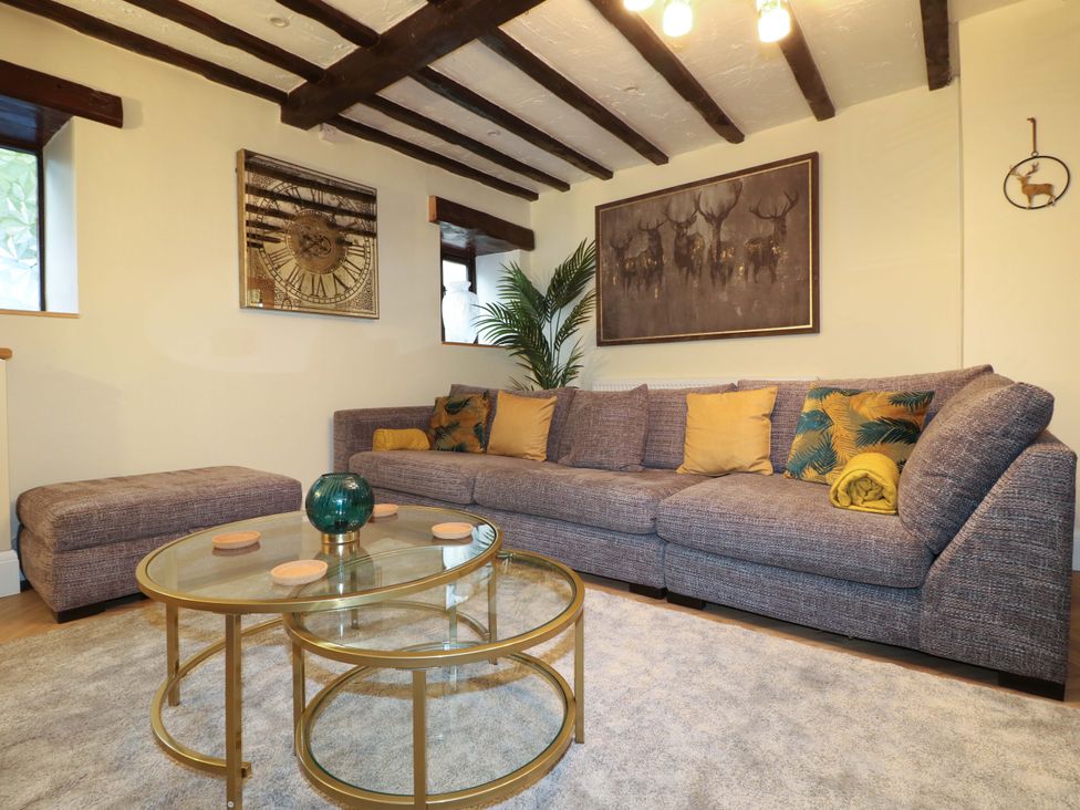 A living room with a sofa and coffee table at Magnolia Cottage Nottingham