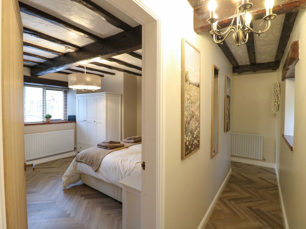 A bedroom with a bed and wardrobe at Magnolia Cottage in Nottingham