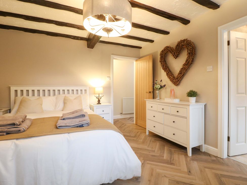 A bedroom with a bed and dresser at Magnolia Cottage Nottingham