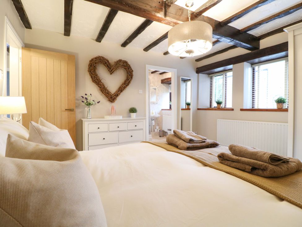 A bedroom with a bed and decorated with a heart on the wall at Magnolia Cottage Nottingham
