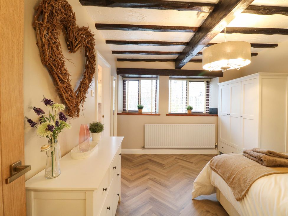 A bedroom with a bed and wardrobe at Magnolia Cottage Nottingham