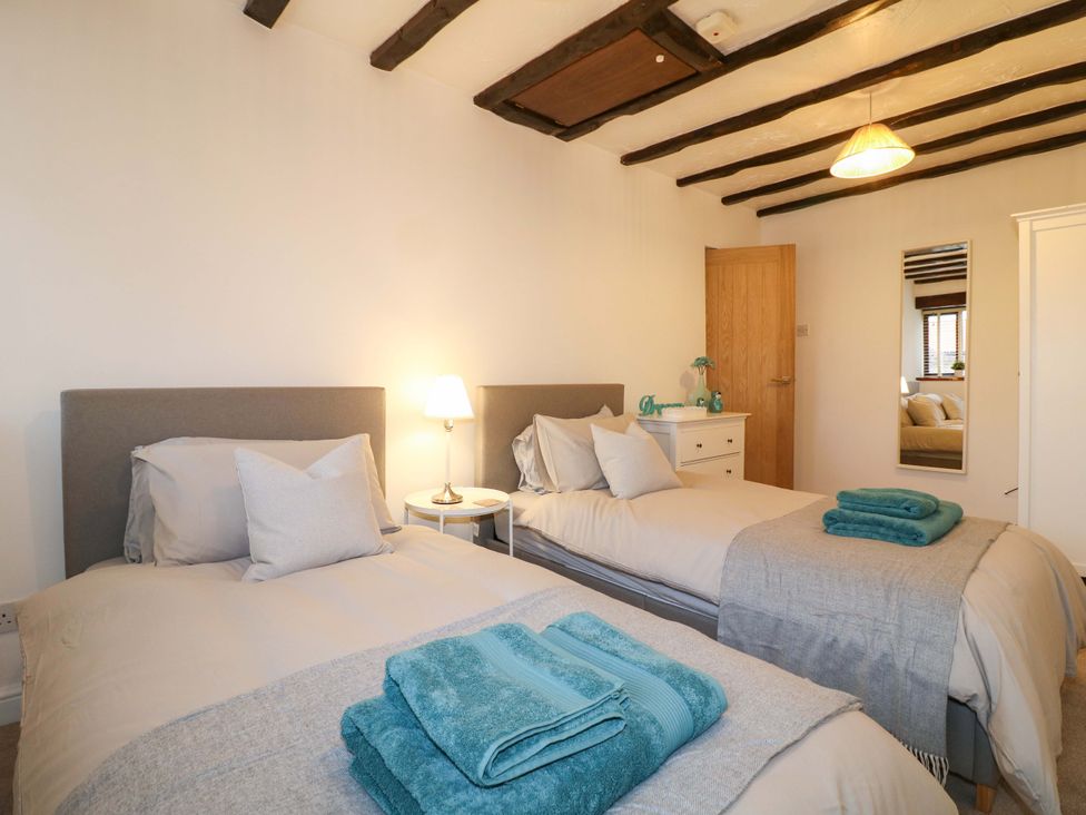 A bedroom with two beds and a nightstand at Magnolia Cottage Nottingham