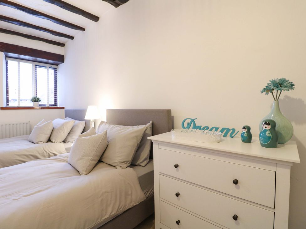A bedroom with a bed and dresser at Magnolia Cottage in Nottingham