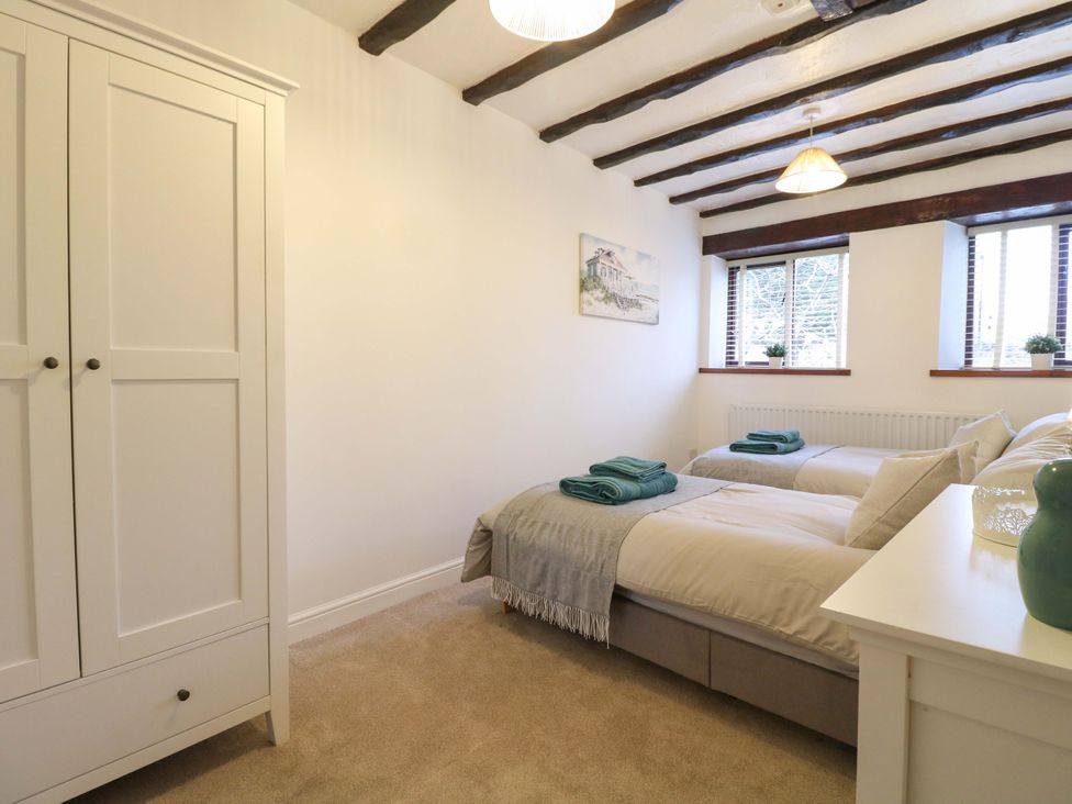 A bedroom with two beds and a wardrobe at Magnolia Cottage Nottingham