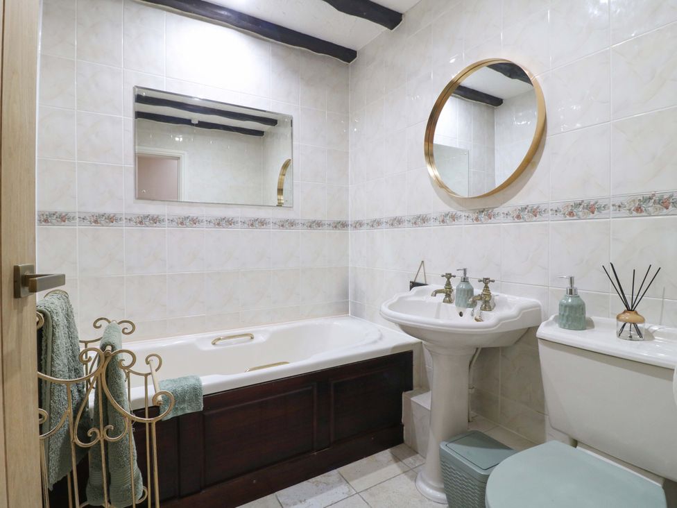 A bathroom with a bathtub, sink, and toilet at Magnolia Cottage Nottingham