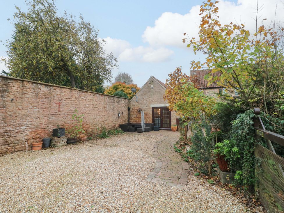 A garden with a gravel driveway and a building at Magnolia Cottage in Nottingham