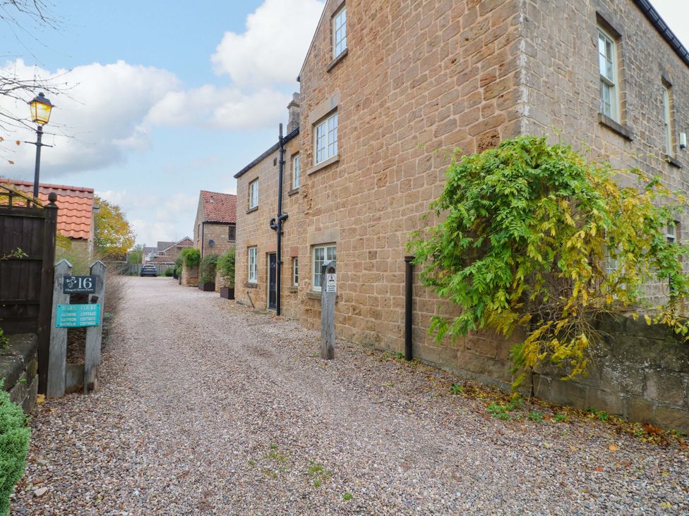 An outdoor view of a building with a gravel driveway at Magnolia Cottage Nottingham