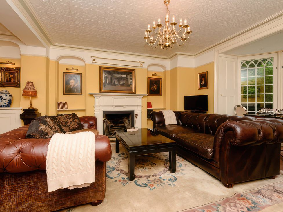 A living room with a fireplace and two sofas at Ladye Park in Liskeard