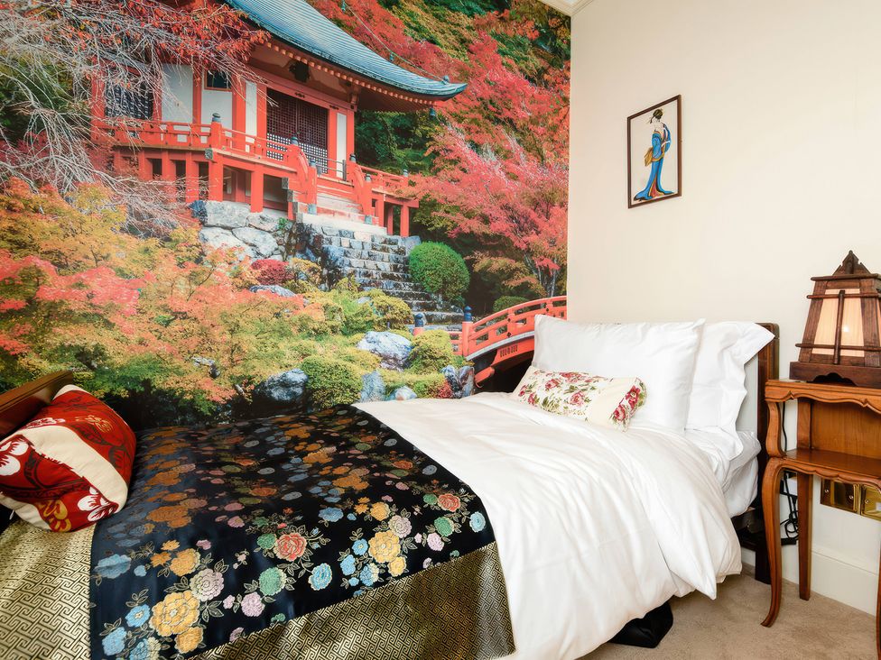 A bedroom with bed and a mural of a Japanese temple at Ladye Park in Liskeard