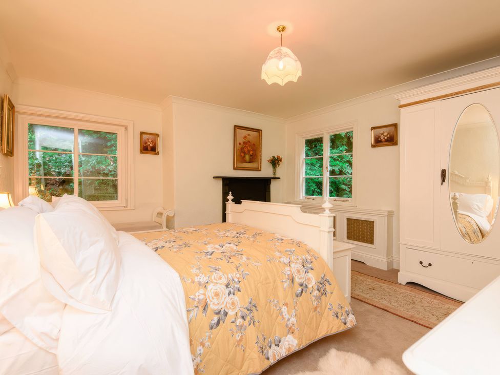 A bedroom with a bed and a wardrobe at Ladye Park in Liskeard