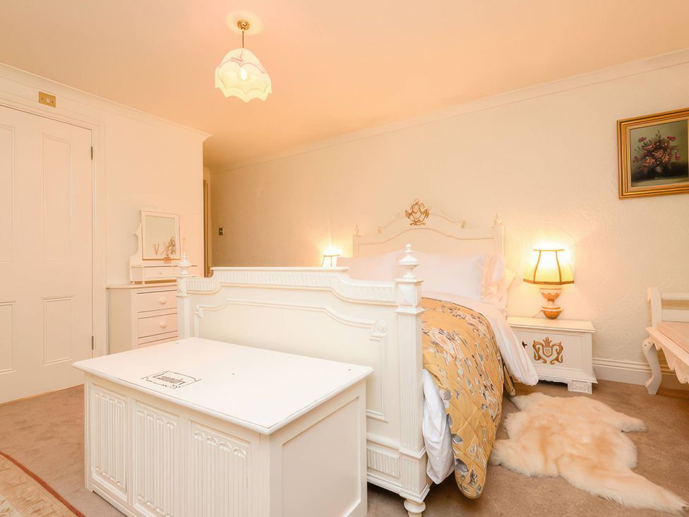 A bedroom with a bed and lighting fixtures at Ladye Park in Liskeard