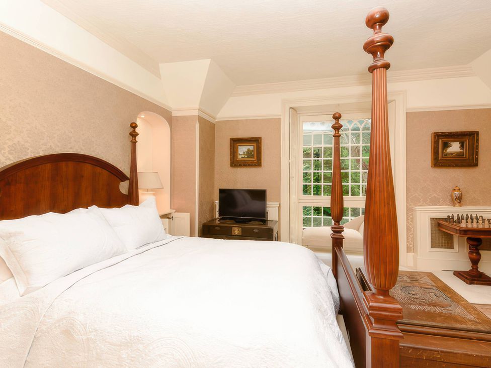 A bedroom with a bed and television at Ladye Park in Liskeard