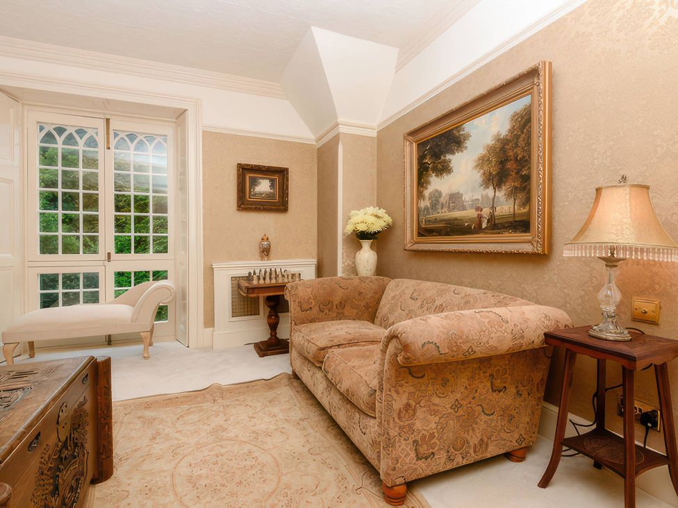 A living room with a sofa and a chess set at Ladye Park in Liskeard