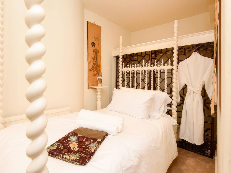 A bedroom with a bed and wall art at Ladye Park in Liskeard