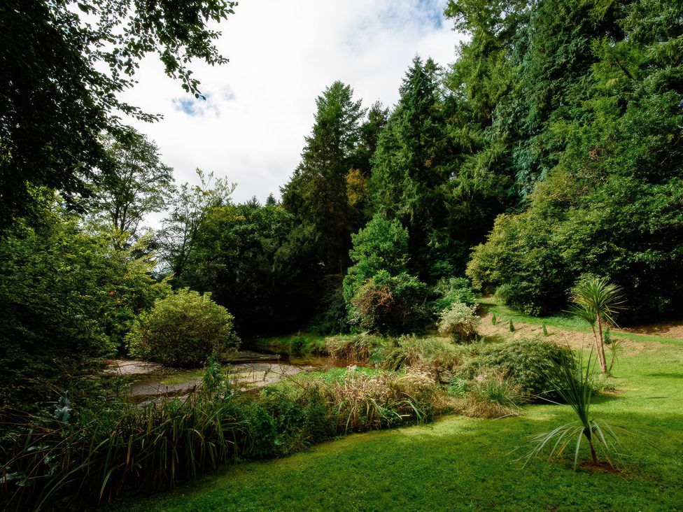 A garden area with trees and a water feature at Ladye Park in Liskeard