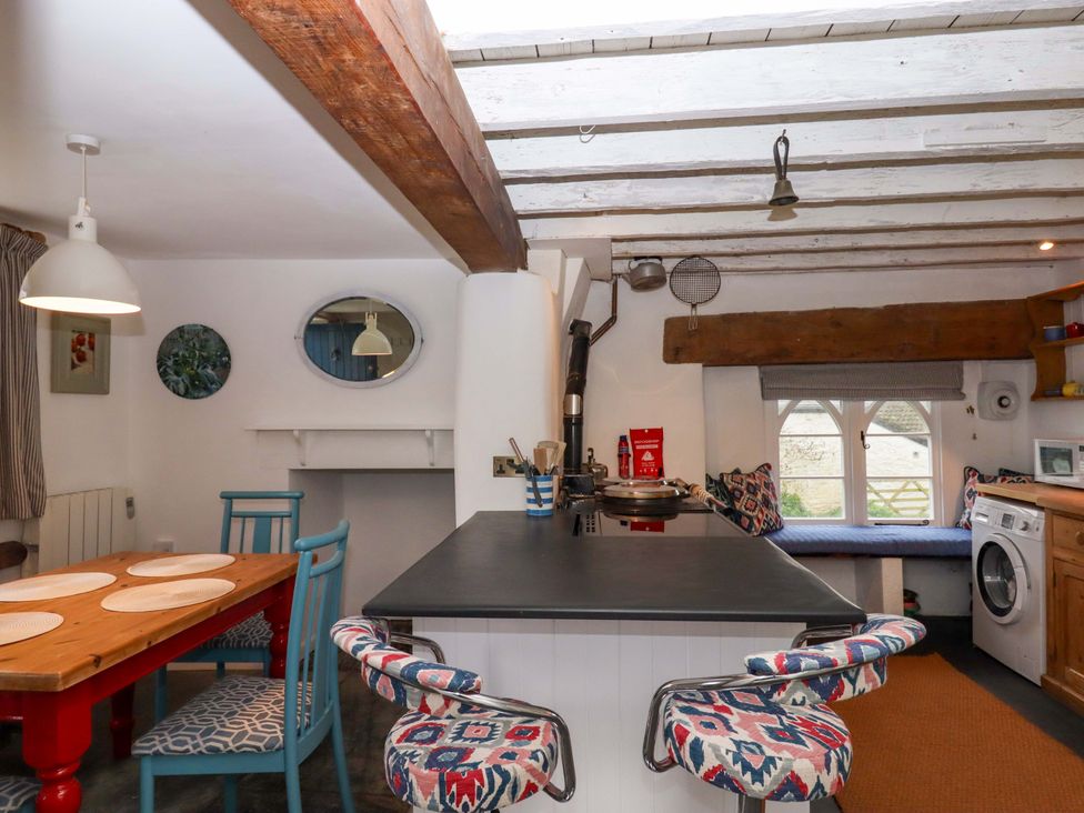 A kitchen with dining table and washing machine at The Old Sunday School in Welcombe near Kilkhampton