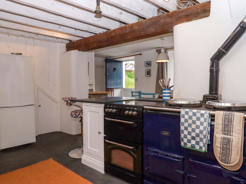 A kitchen with an Aga stove and a white fridge at Old Sunday School Welcombe near Kilkhampton