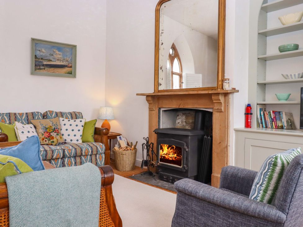 A living room with a fireplace and bookshelf at Old Sunday School Welcombe near Kilkhampton