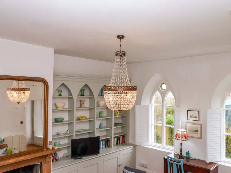 A living room with a chandelier and shelf at Old Sunday School in Welcombe near Kilkhampton