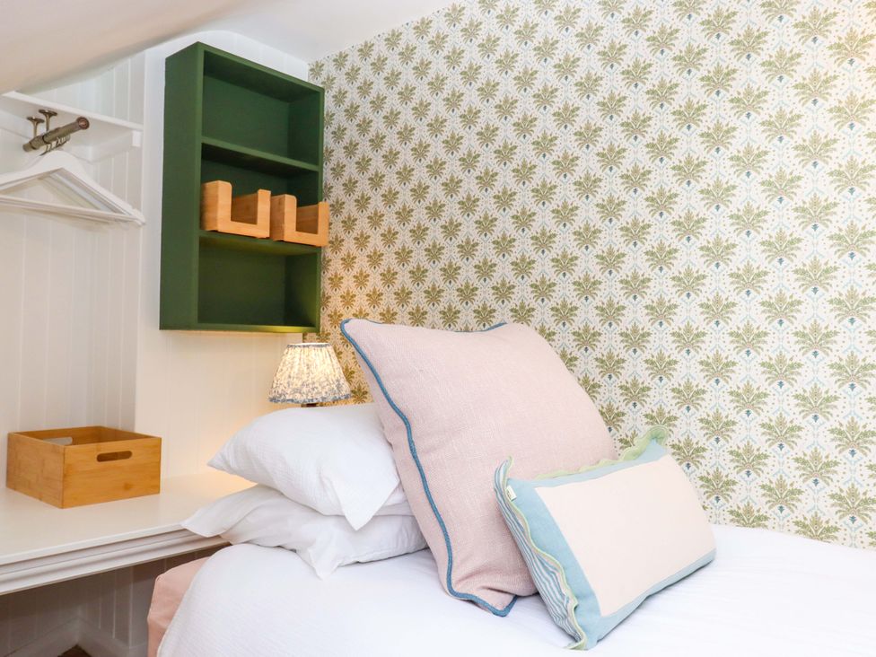 A bedroom with a bed and pillows at Old Sunday School in Welcombe near Kilkhampton