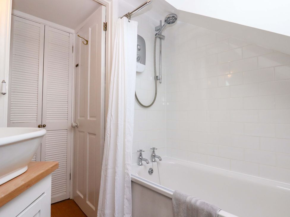 A bathroom featuring a bathtub, shower, and sink at Old Sunday School Welcombe near Kilkhampton
