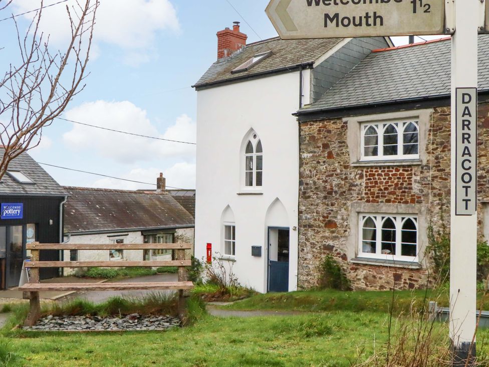 A building with a signpost and bench at Old Sunday School Welcombe near Kilkhampton