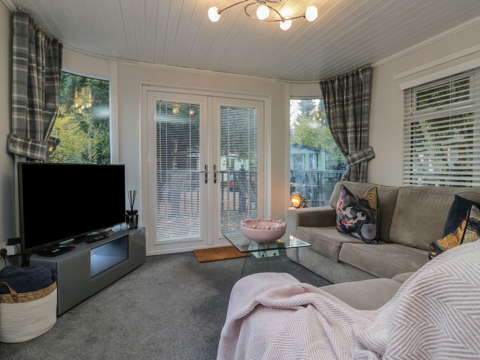 A snug with a sofa and coffee table at Evermore Lodge, 48 Calgarth Park, White Cross Bay, Windermere