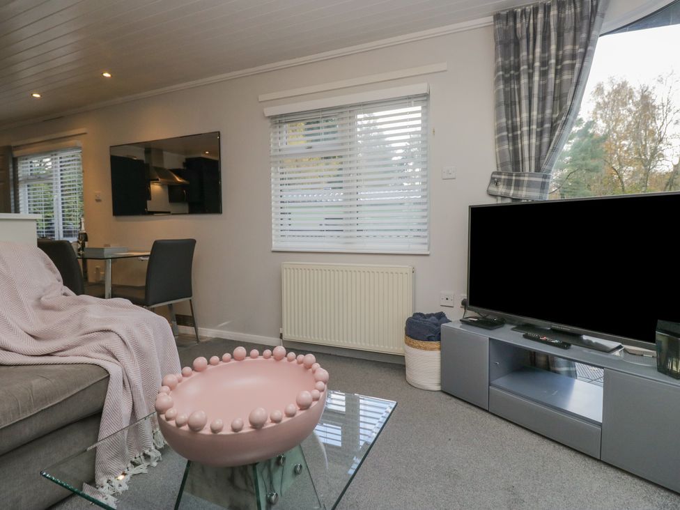 A living room with a sofa and television at Evermore Lodge 48 Calgarth Park, White Cross Bay, Windermere