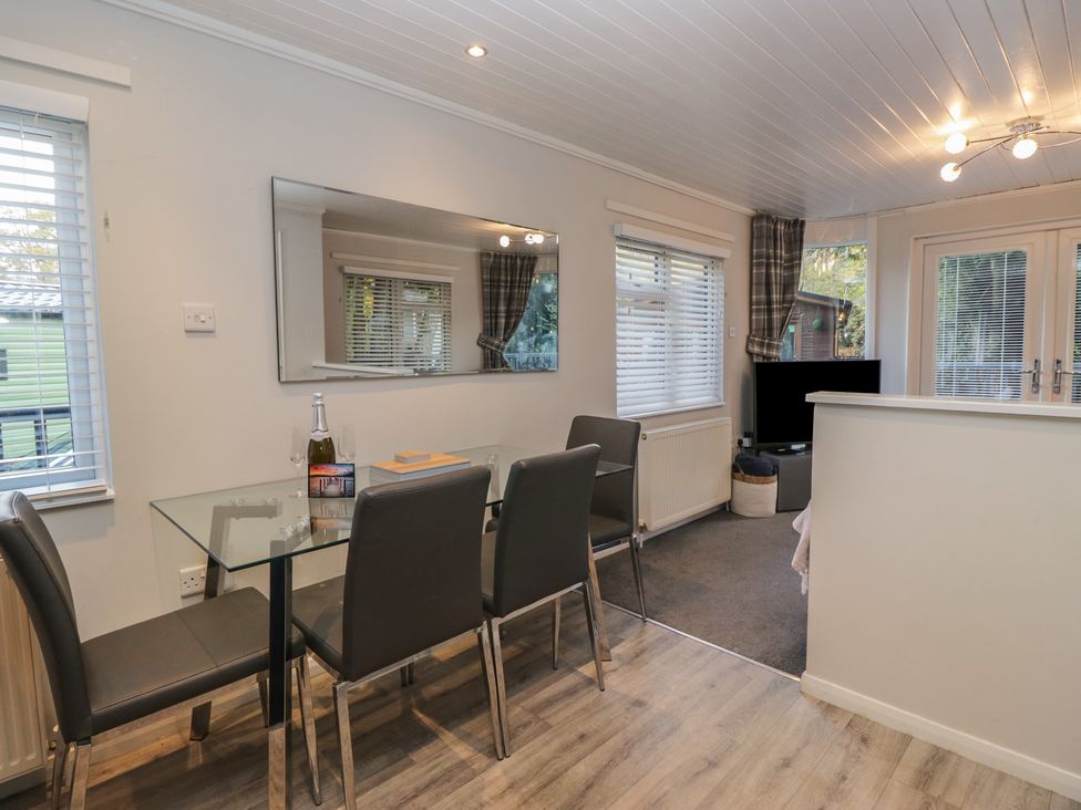A dining room with a table and chairs at Evermore Lodge, 48 Calgarth Park, White Cross Bay, Windermere
