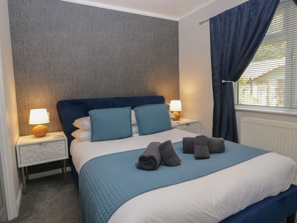 A bedroom with a bed and bedside table at Evermore Lodge 48 Calgarth Park, White Cross Bay, Windermere