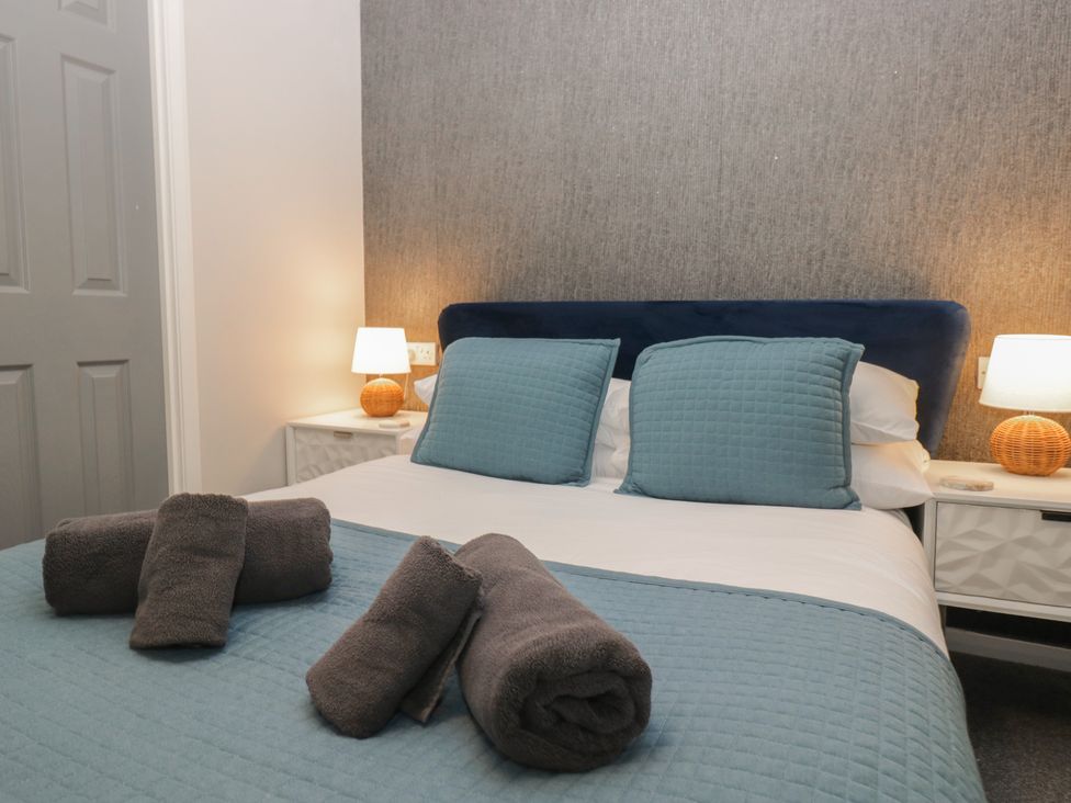 A bedroom with a bed and towels at Evermore Lodge, 48 Calgarth Park, White Cross Bay, Windermere