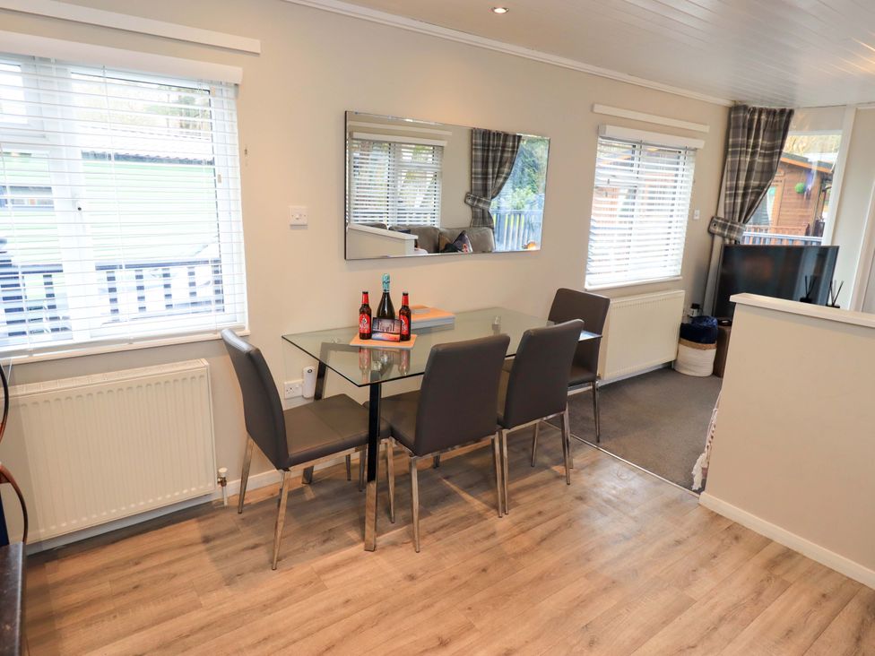 A dining room with a table and chairs at Evermore Lodge 48 Calgarth Park, White Cross Bay, Windermere