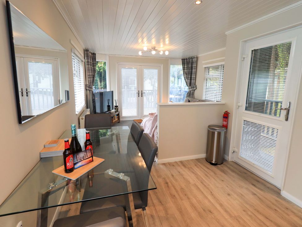 A dining room with a table and chairs at Evermore Lodge, 48 Calgarth Park, White Cross Bay, Windermere