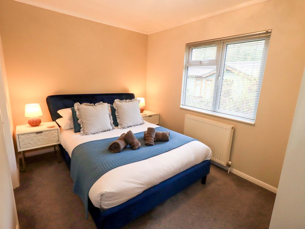 A bedroom with a bed and bedside tables at Evermore Lodge, 48 Calgarth Park, White Cross Bay, Windermere