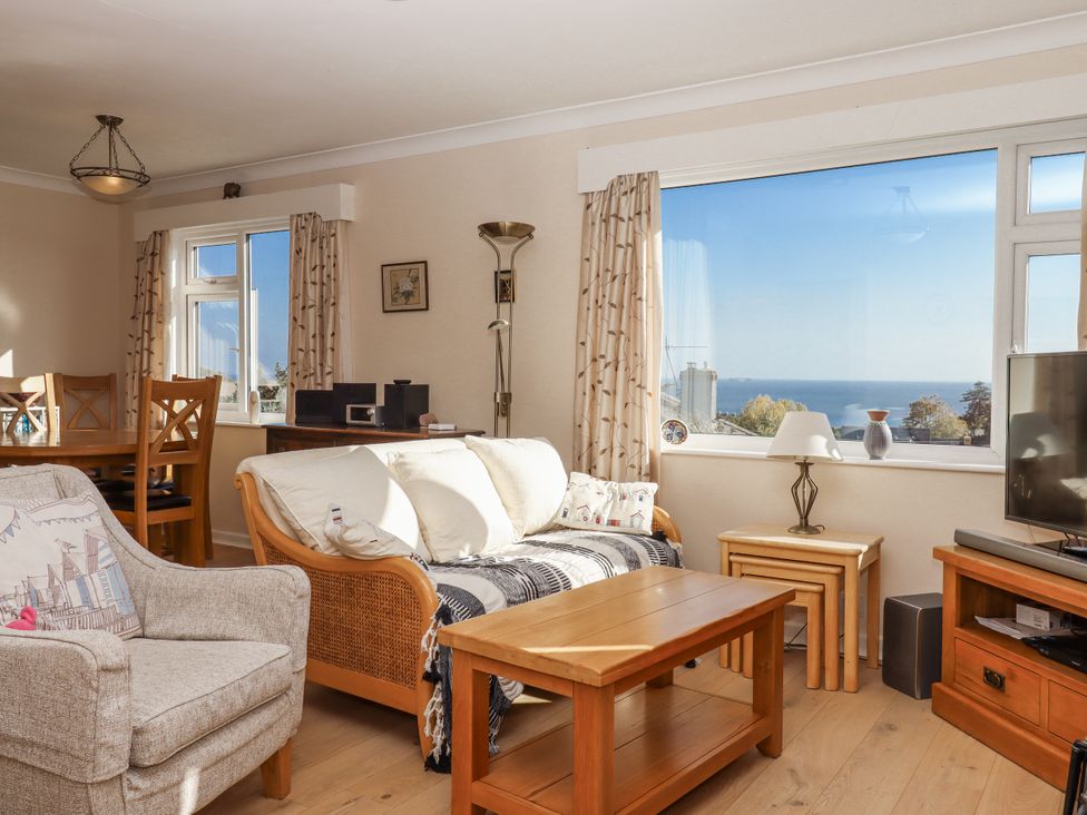 A living room with a sofa and dining area at Woodbury in Teignmouth
