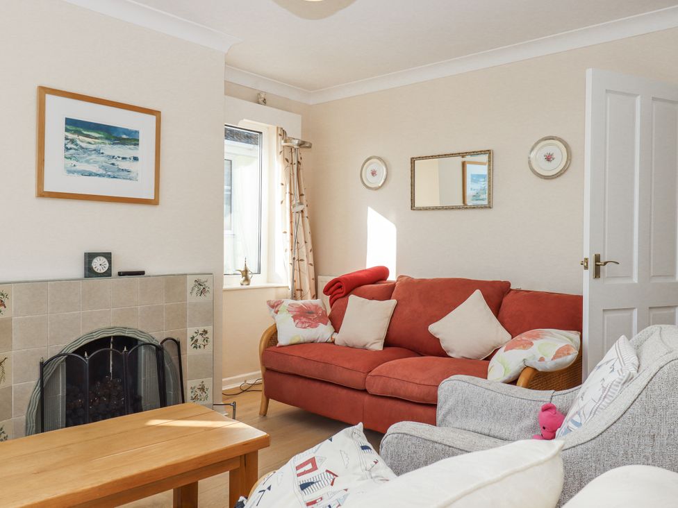 A living room with a red sofa and coffee table at Woodbury in Teignmouth