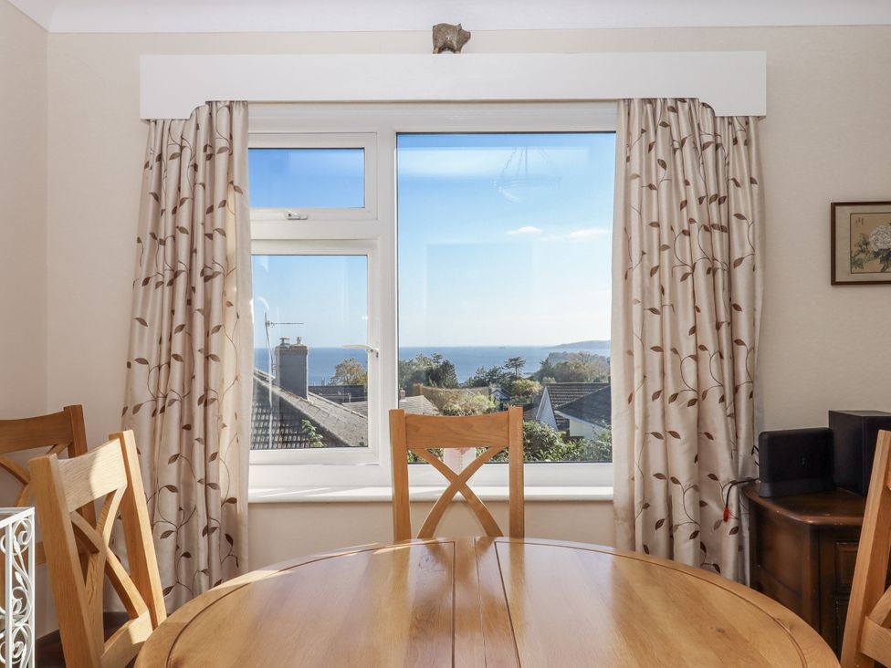 A dining room with a view of the sea at Woodbury Teignmouth