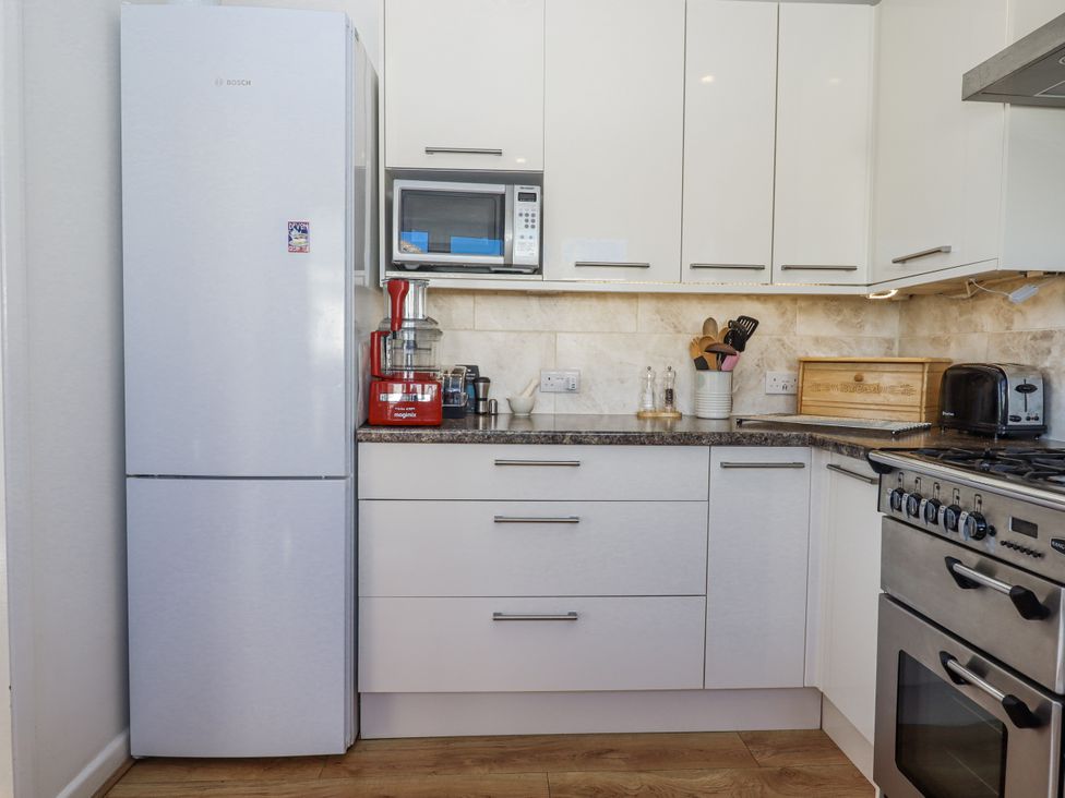 A kitchen with appliances and storage at Woodbury in Teignmouth