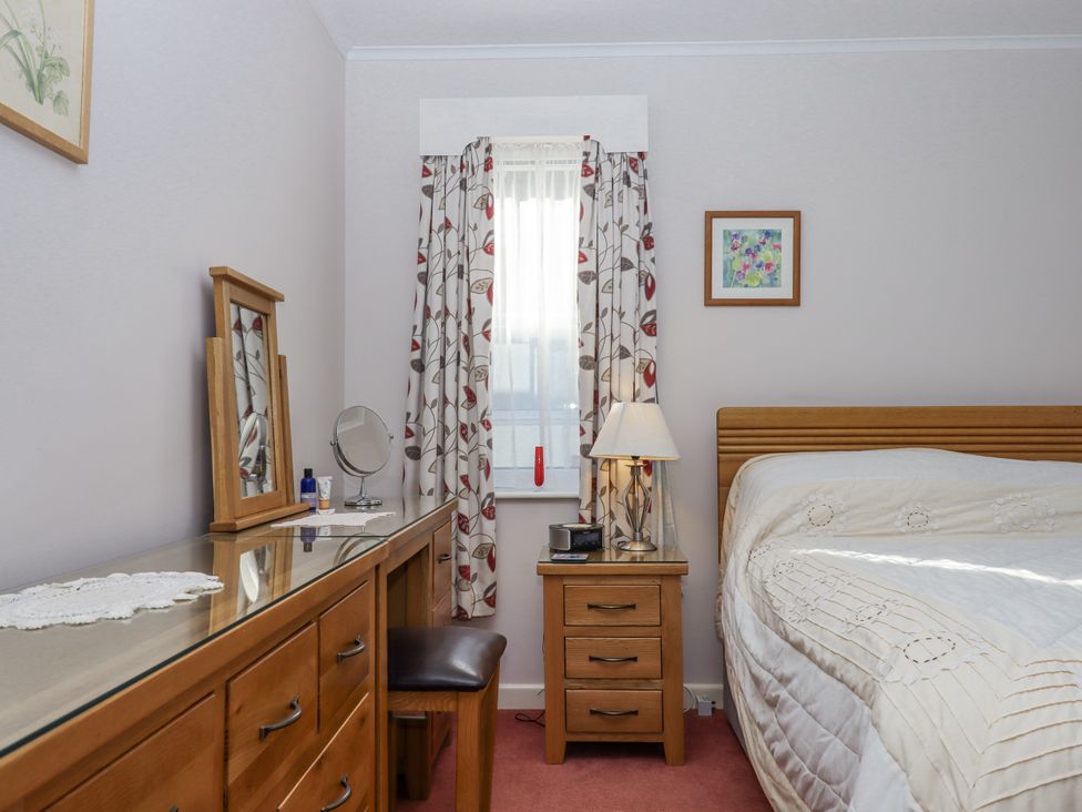 A bedroom with a bed and dressing table at Woodbury in Teignmouth