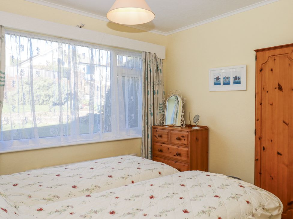 A bedroom with two beds and a dressing table at Woodbury in Teignmouth