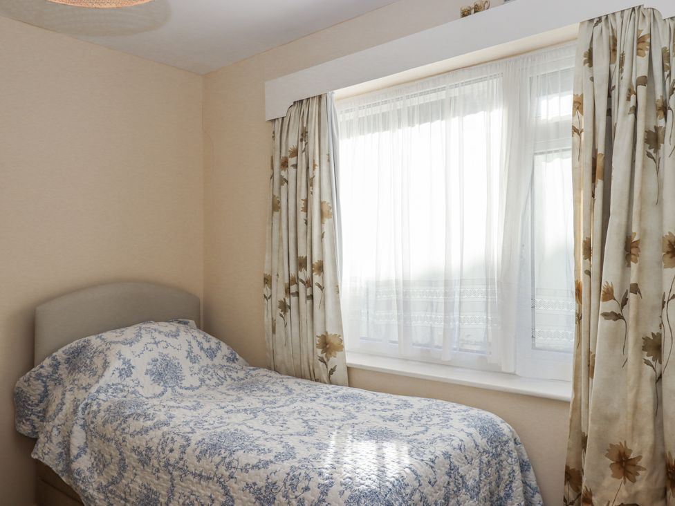 A bedroom with a bed and window at Woodbury in Teignmouth