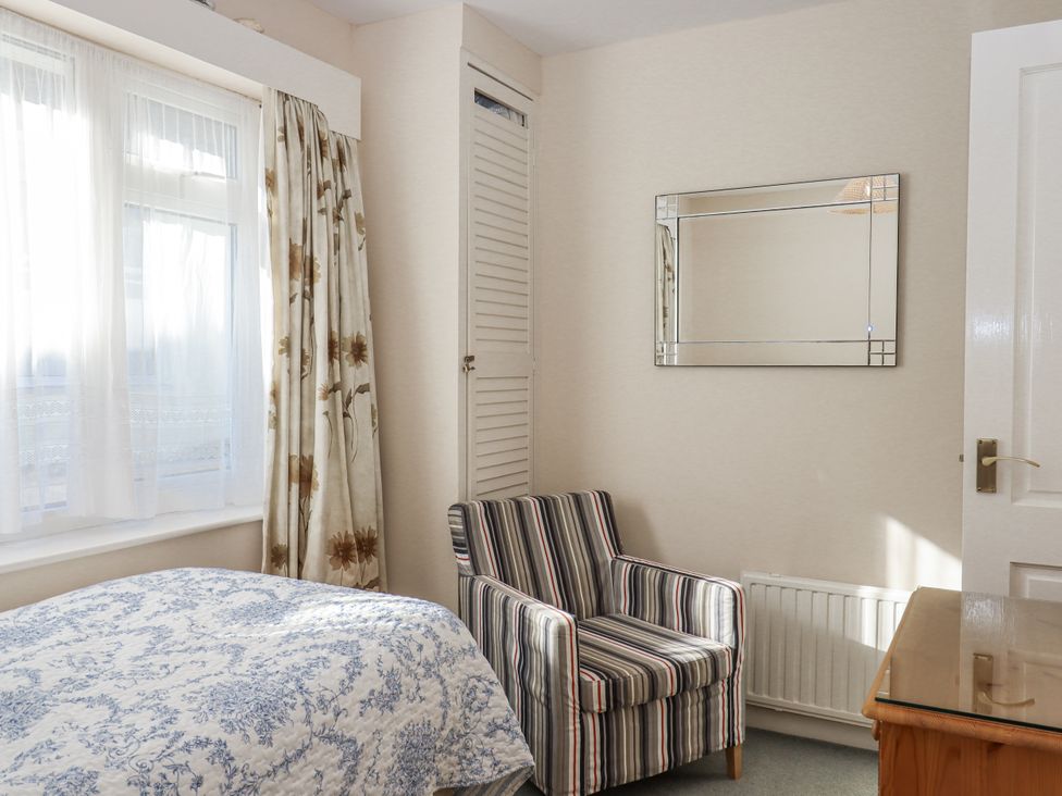 A bedroom with a bed and chair at Woodbury in Teignmouth
