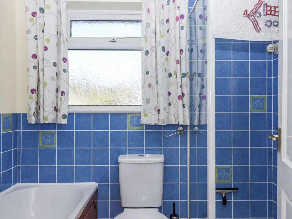 A bathroom with a bathtub and toilet at Woodbury in Teignmouth