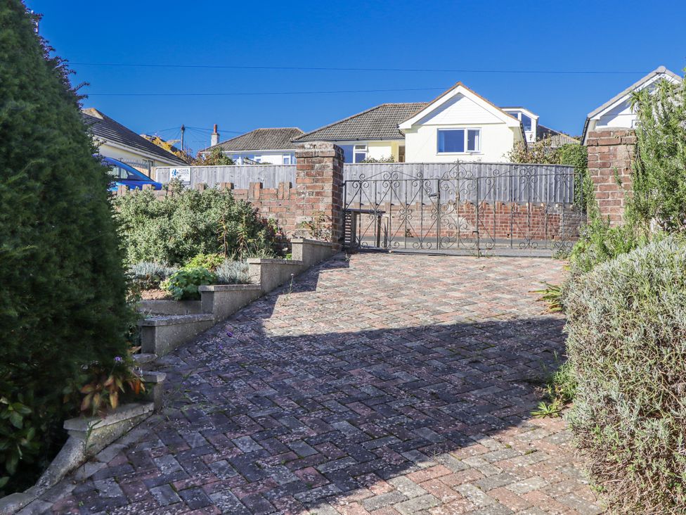 A driveway with a gate and plants at Woodbury in Teignmouth
