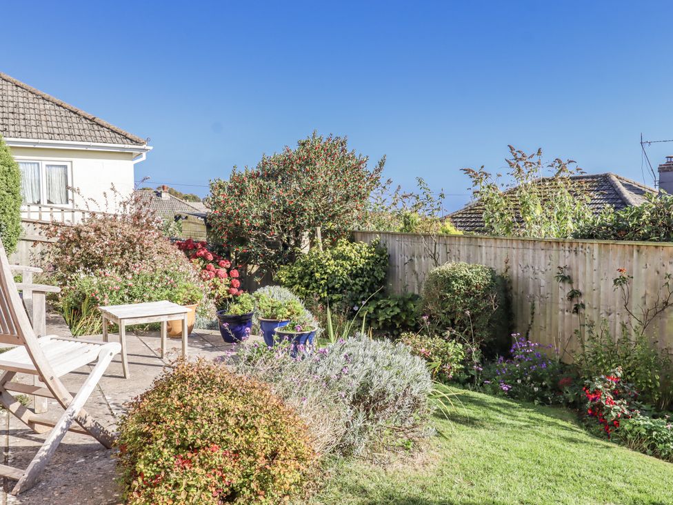 A garden with flowers and seating at Woodbury in Teignmouth