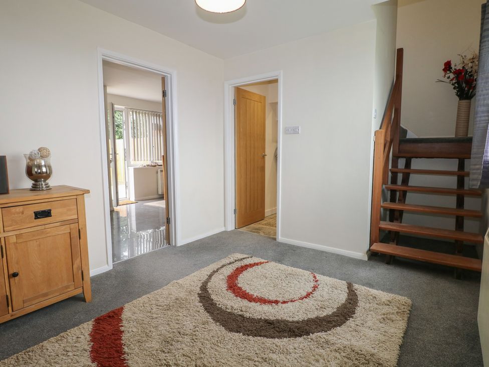 A hallway with a rug and wooden cabinet at Walmer Court Farmhouse in Deal