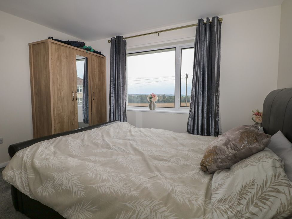 A bedroom with a bed and wardrobe at Walmer Court Farmhouse in Deal